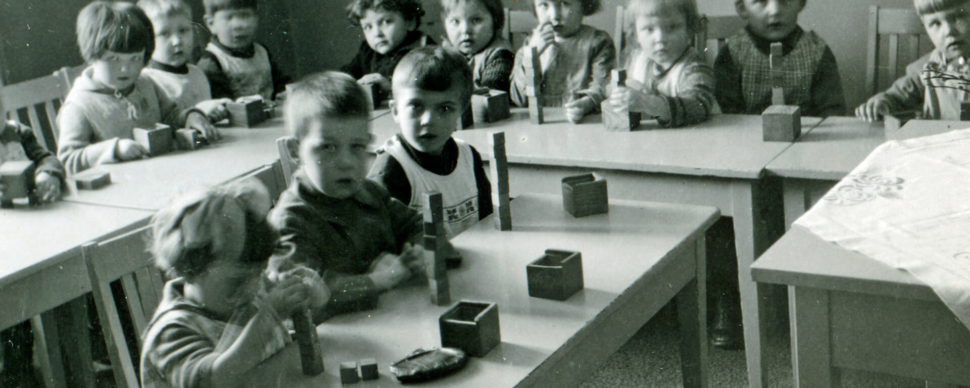 Lapsia rakentelemassa palikoista torneja Kotivaran lastentarhassa, 1920-luvun loppu. Lastentarhamuseon valokuvakokoelma..