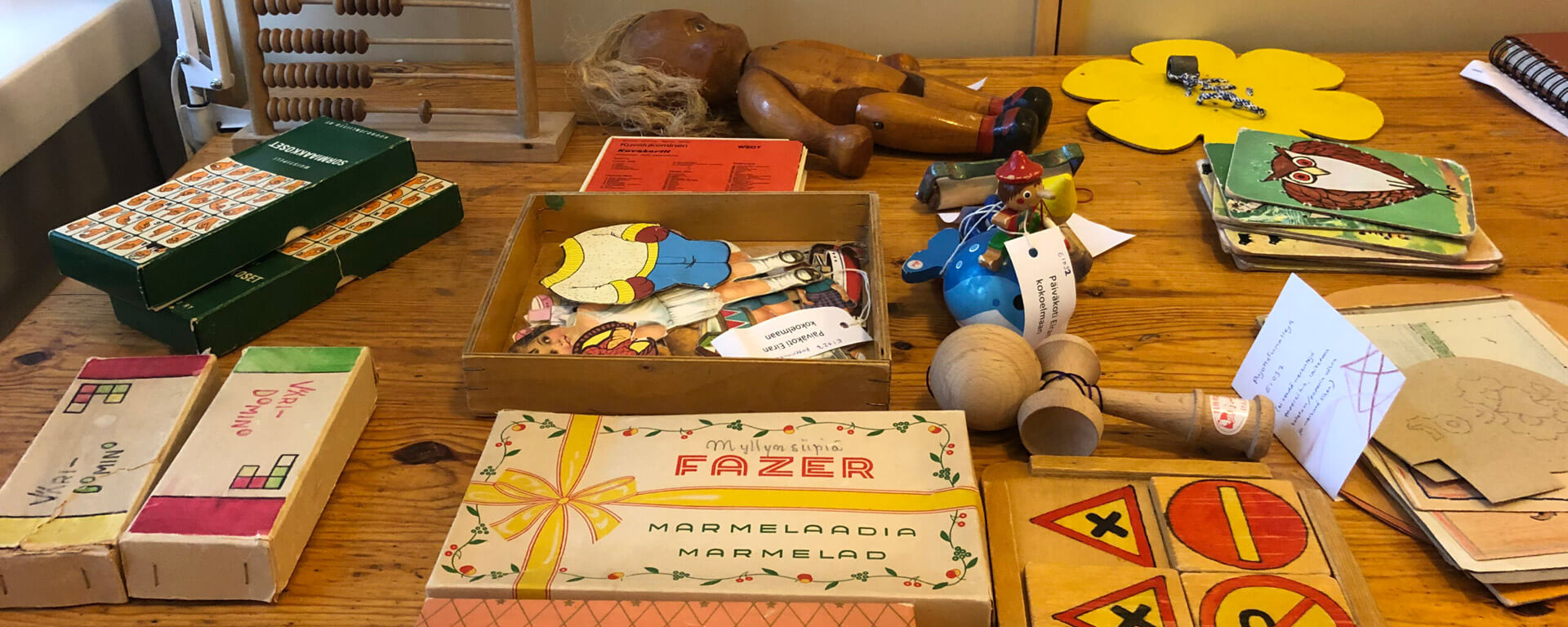 Päiväkoti Eirasta Lastentarhamuseoon lahjoitettuja esineitä pöytäpinnalla odottamassa käsittelyä. Kuva: Matleena Gaetz