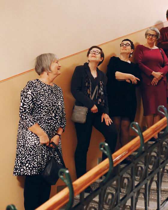 Ebeneser-talon 110-vuotisjuhlassa talon kaikki toimijat järjestivät erityistä ohjelmaa samaisena juhlapäivänä marraskuussa 2018. Tässä kuvassa on menossa konsertti, joka järjestettiin Ebeneser-talon jälki-jugendtyylisen pääportaikon ylimmällä tasanteella. Musiikki kaikui kauniisti portaikon läpi, joka oli täynnä ihmisiä. Tässä kuvassa viisi ihmistä seisoo hymyillen ja konserttia kuunnellen.