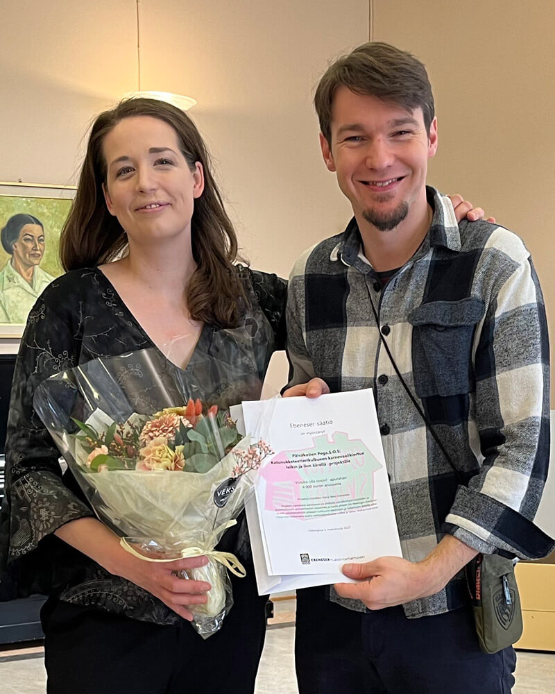 Kuvassa vasemmalla Maria Baric vieressään Nemanja Stojanovic. Baric pitelee kukkakimppua ja Stojanovic kunniakirjaa, joka on annettu osana apurahajuhlaa.