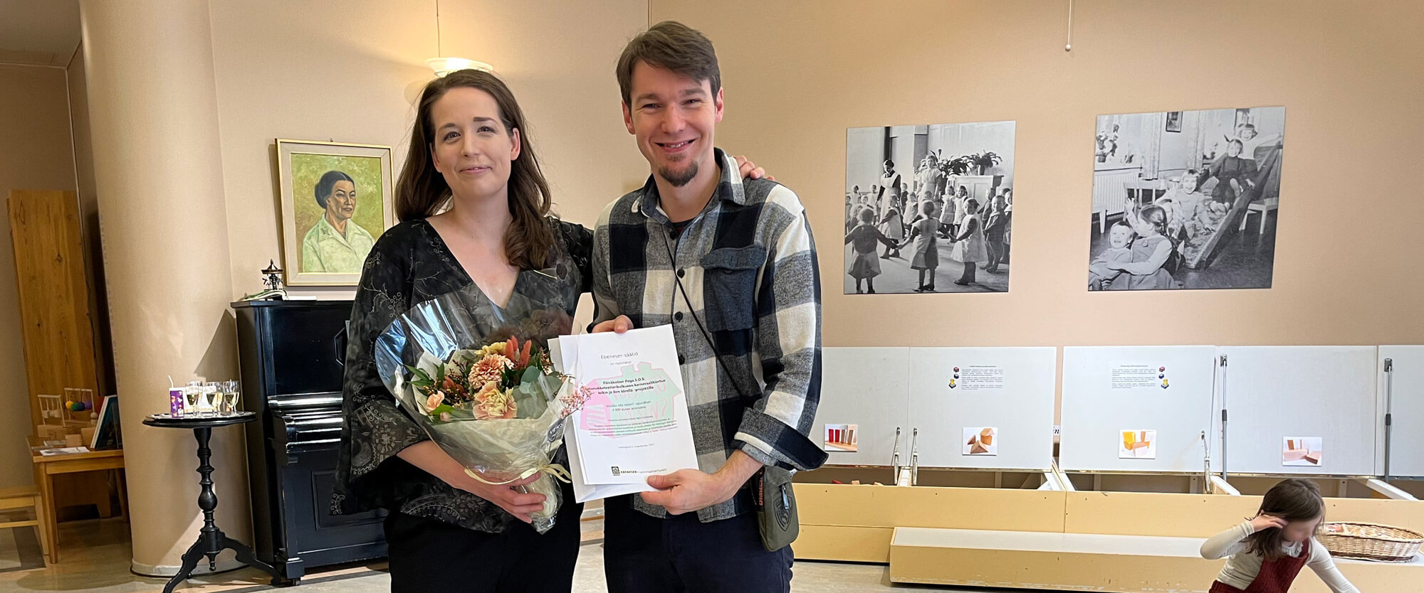 Kuvassa vasemmalla Maria Baric vieressƤƤn Nemanja Stojanovic. Baric pitelee kukkakimppua ja Stojanovic kunniakirjaa, joka on annettu osana apurahajuhlaa.