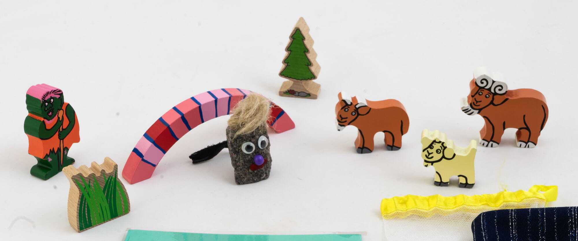 Kuvassa on pieninä figuureina Kolme pukkia ja peikko -sadun hahmot sekä silta ja kuusipuu. Hahmot ovat olleet käytössä Väinölän päiväkodissa Tuusulassa. Nykyisin hahmot kuuluvat Lastentarhamuseon esinekokoelmaan.