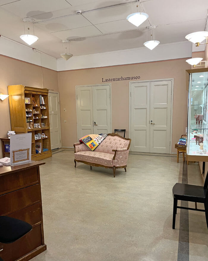 Ennen remonttia aulan seinät olivat pehmeän roosan väriset. Boordiraja oli asetettu lähelle kattoa ja seinän yläosa maalattu katon kanssa valkoiseksi. Roikkuvat kattovalaisimet olivat kartionmalliset. Seinävalaisimet olivat samasta valaisinsarjasta.